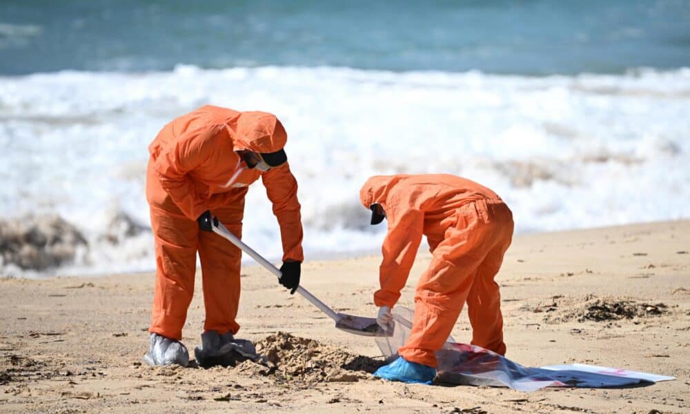 Trabajadores de limpieza retiran las bolas de alquitran aparecidas en la playa de Coogee, en Sídney.
EFE/EPA/DAN HIMBRECHTS NO ARCHIVING AUSTRALIA AND NEW ZEALAND OUT