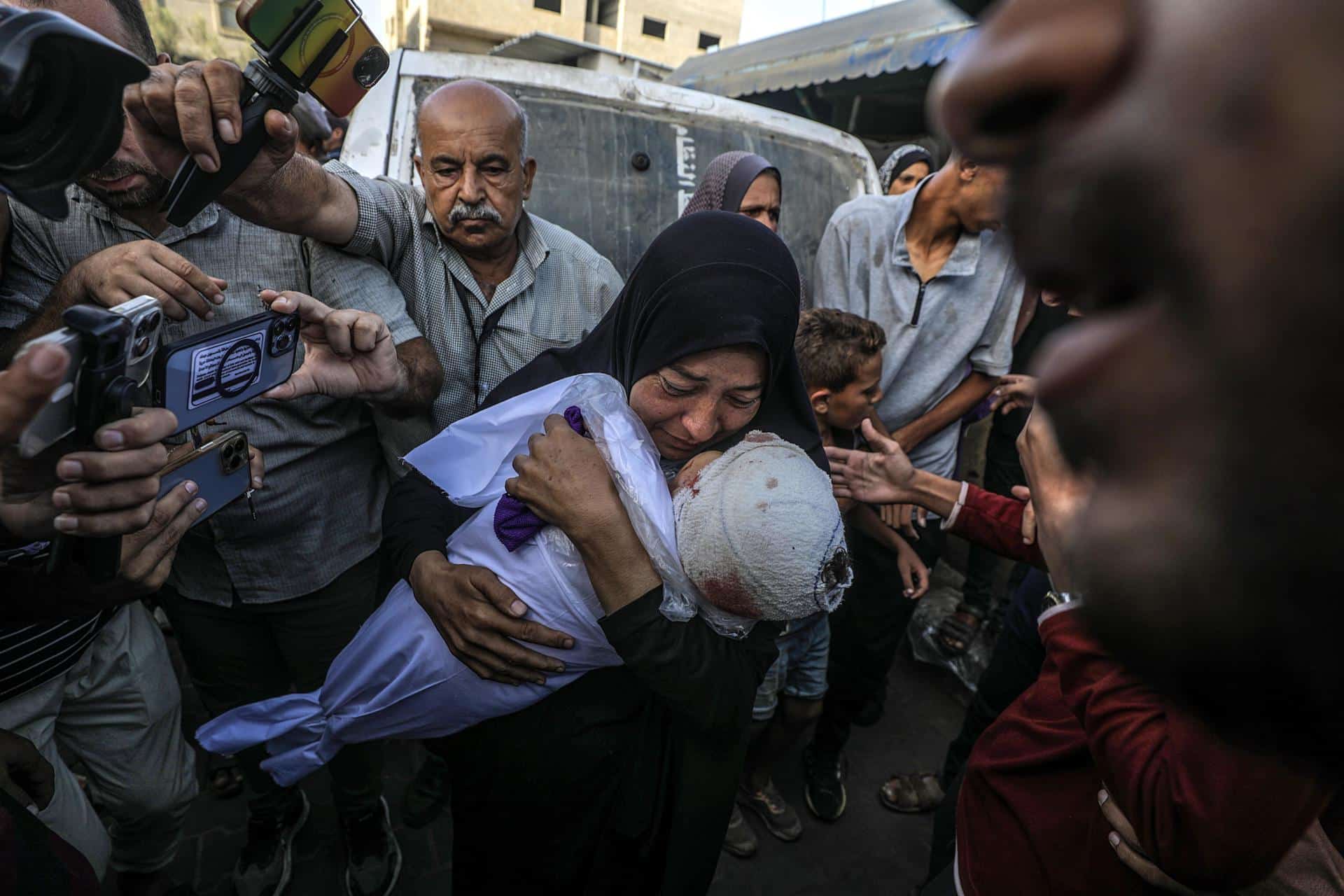 Una mujer palestina, abuela del bebé de un año y medio asesinado, Yaman Al Zaneen, llora mientras carga su cuerpo durante el funeral en Deir al Balah, en el centro de la Franja de Gaza, el 14 de octubre de 2024. Según el Ministerio de Salud palestino, 23 personas, incluidos niños, murieron después de que una escuela que albergaba a palestinos desplazados internamente en el campamento de Nuseirat fuera atacada por Israel el 13 de octubre. Más de 42.200 palestinos y más de 1.400 israelíes han muerto, según el Ministerio de Salud palestino y el Ejército israelí, Tsahal, desde que militantes de Hamás lanzaron un ataque contra Israel desde la Franja de Gaza el 7 de octubre de 2023, y las operaciones israelíes en Gaza y Cisjordania que le siguieron. EFE/EPA/MOHAMMED SABER