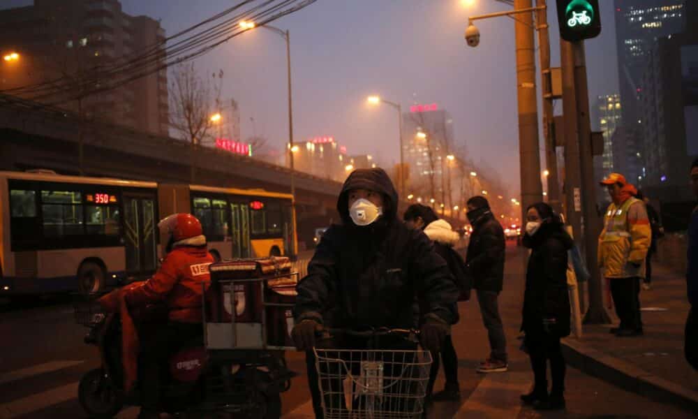 En la imagen de archivo, peatones utilizan mascarillas para protegerse de la contaminación en Pekín (China). EFE/How Hwee Young