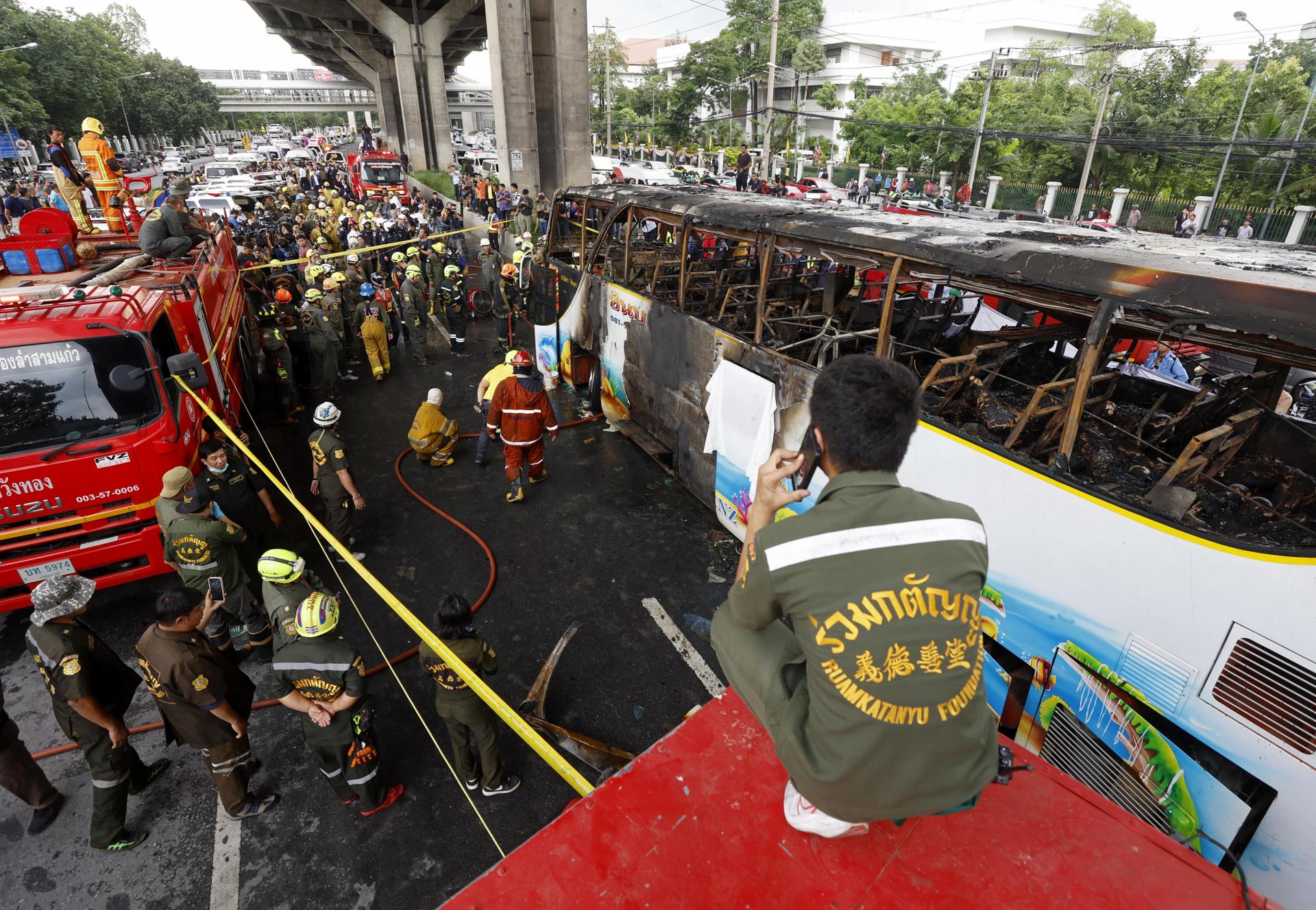 Los equipos de emergencia inspeccionan el autobús calcinado en el norte de Bangkok, que transportaba a estudiantes y profesores.
EFE/EPA/NARONG SANGNAK