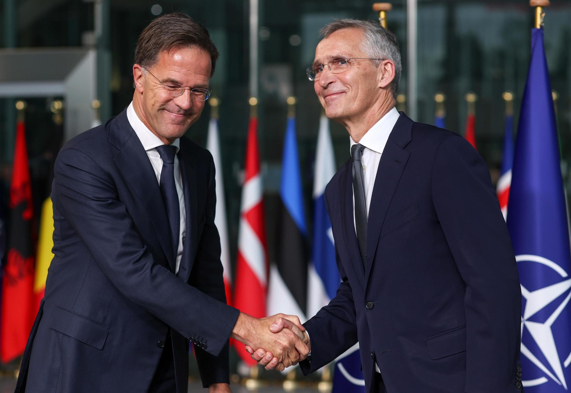 El neerlandés Mark Rutte (i) se convirtió este martes en el nuevo secretario general de la OTAN, tras suceder al noruego Jens Stoltenberg (d) en una reunión del Consejo del Atlántico Norte celebrada en Bruselas. EFE/ EPA/Olivier Hoslet