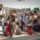 Migrantes hacen fila en una estación migratoria 'El Chaparral', este viernes en la ciudad de Tijuana en Baja California (México). EFE/Joebeth Terriquez