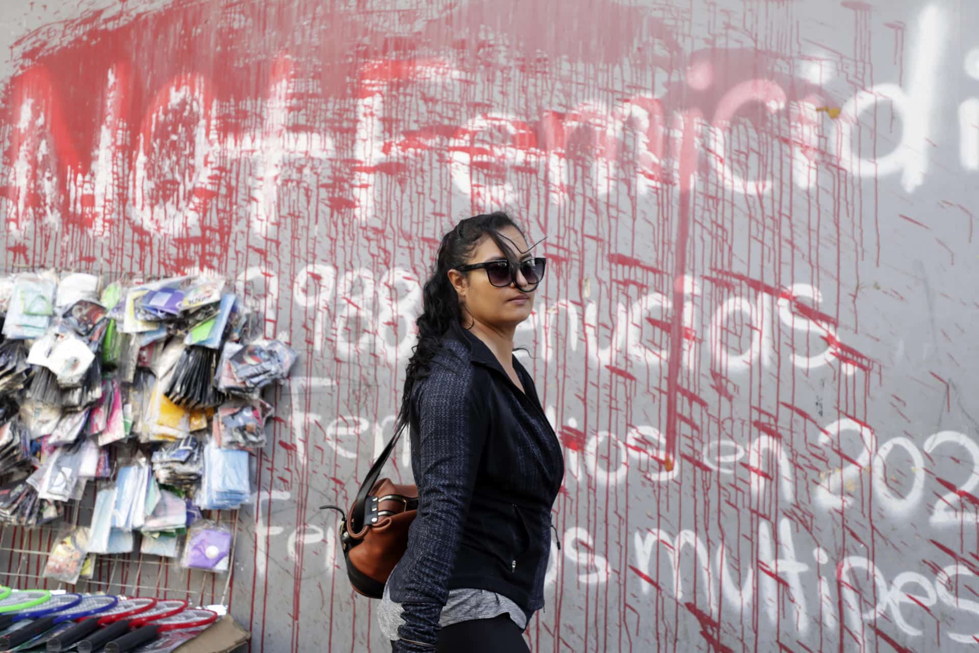 Una mujer camina frente a un muro pintado con un grafiti en contra de los feminicidios este 9 de octubre de 2024 en Tegucigalpa (Honduras). EFE/STR