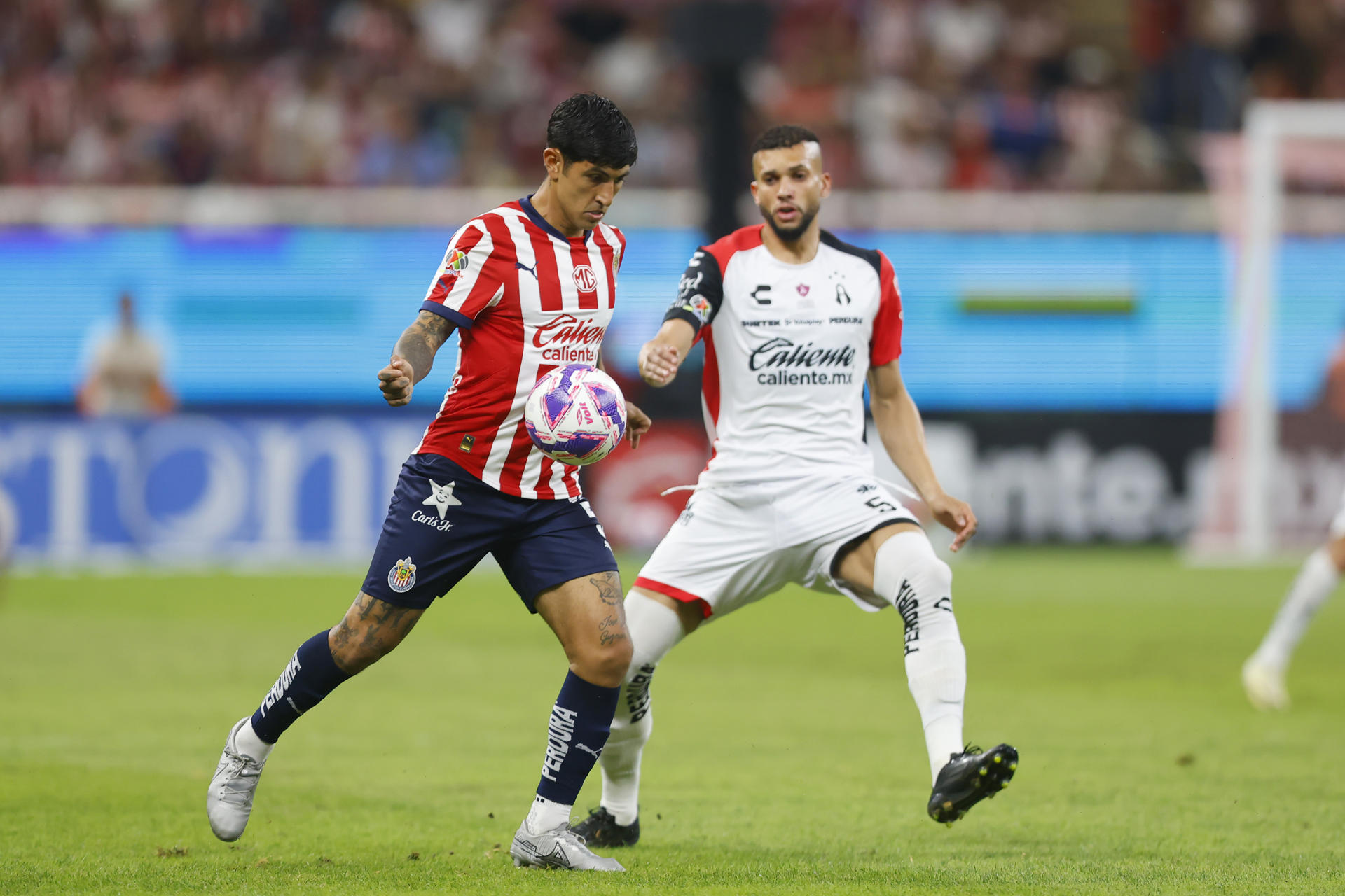 Imagen de archivo de Víctor Guzmán (i) del Guadalajara, quien disputa el balón con Matheus Doria (d) de Atlas. EFE/ Francisco Guasco