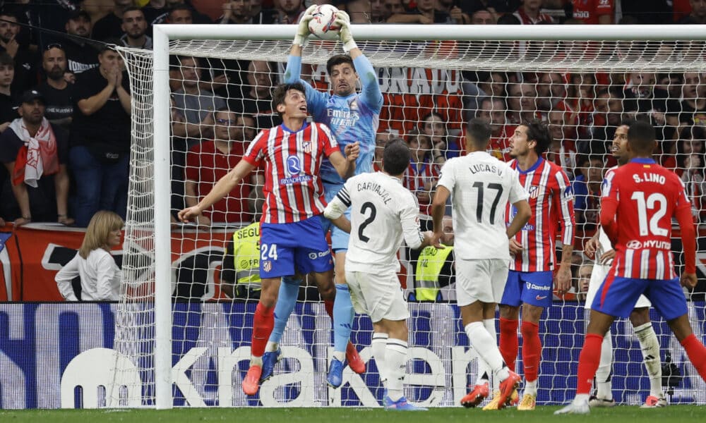 El portero Real Madrid Thibaut Courtois (2-i) detiene un balón ante Robin Le Normand (i), del Atlético, en el estadio Civitas Metropolitano en foto de archivo de JJ Guillén. EFE