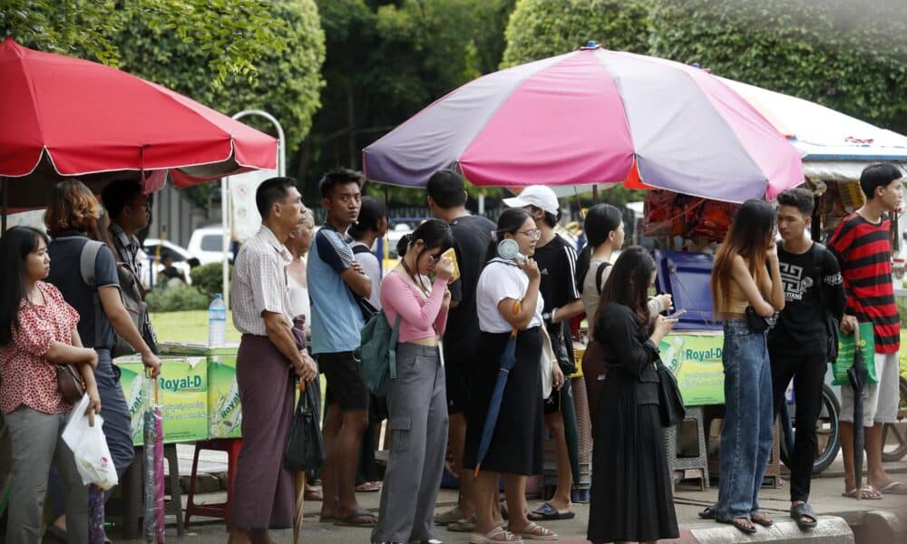 Habitantes de Rangún, la antigua capital y la ciudad más poblada de Birmania (Myanmar), aguardan la llegada de un autobús en una fotografía de archivo del pasado agosto. EFE/EPA/NYEIN CHAN NAING