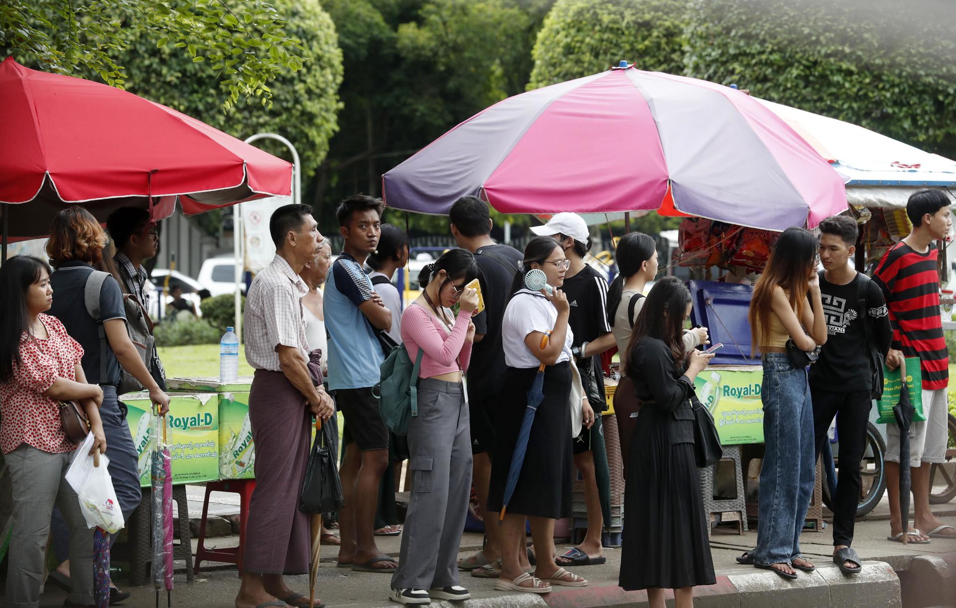 Habitantes de Rangún, la antigua capital y la ciudad más poblada de Birmania (Myanmar), aguardan la llegada de un autobús en una fotografía de archivo del pasado agosto. EFE/EPA/NYEIN CHAN NAING