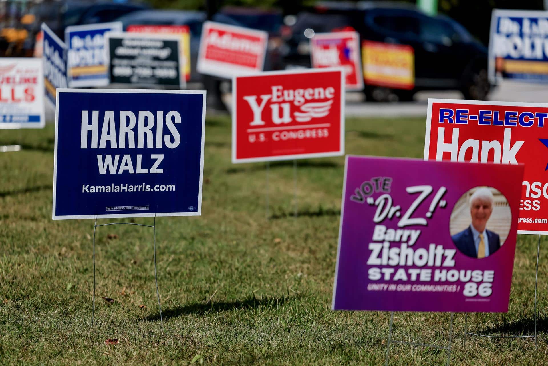 Un cartel de campaña para la fórmula presidencial demócrata de Kamala Harris y Tim Walz (izq.) se ve con otros candidatos de campaña locales durante el primer día de votación anticipada en Georgia para las elecciones presidenciales de Estados Unidos y otras carreras en la oficina principal de registro de votantes y elecciones del condado de Dekalb en Decatur, Georgia, EE. UU., el 15 de octubre de 2024. EFE/ERIK S. MENOR