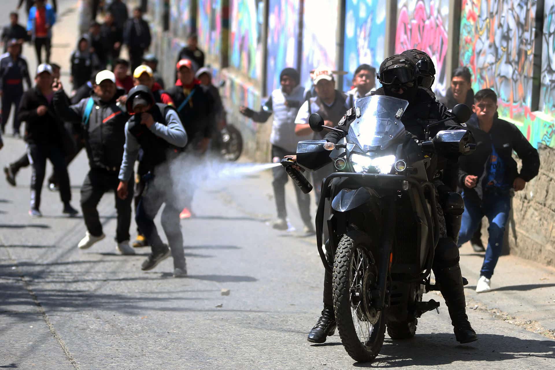 Un policía rocía gas pimienta durante una jornada protestas de conductores del transporte público este miércoles, en La Paz (Bolivia). EFE/ Luis Gandarillas