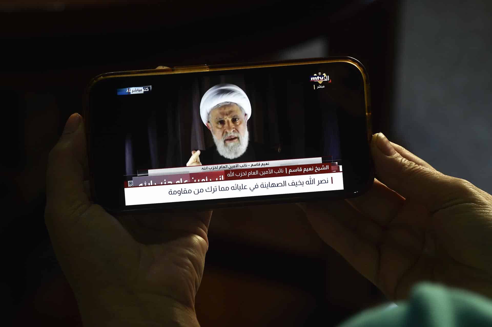 Una persona ve en su teléfono móvil un discurso de Naim Qassem transmitido por el canal de televisión Al-Manar de Hizbulá, en Beirut, Líbano, el 08 de octubre de 2024. EFE/EPA/WAEL HAMZEH