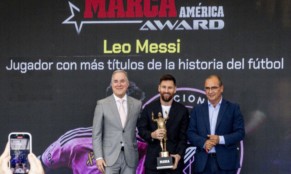 El futbolista argentino Lionel Messi (c) sostiene el trofeo del Premio Marca América junto al dueño del Inter Miami, Jorge Más (i), y el director del diario Marca, Juan Ignacio Gallardo (d), durante una ceremonia, este jueves en el Estadio Chase en Fort Lauderdale, en Florida (Estados Unidos). EFE/ Eva Marie Uzcátegui