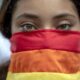 Fotografía de archivo en donde se ve a una mujer que cubre la mitad de su rostro con la bandera arcoíris en Managua (Nicaragua). EFE/ Jorge Torres