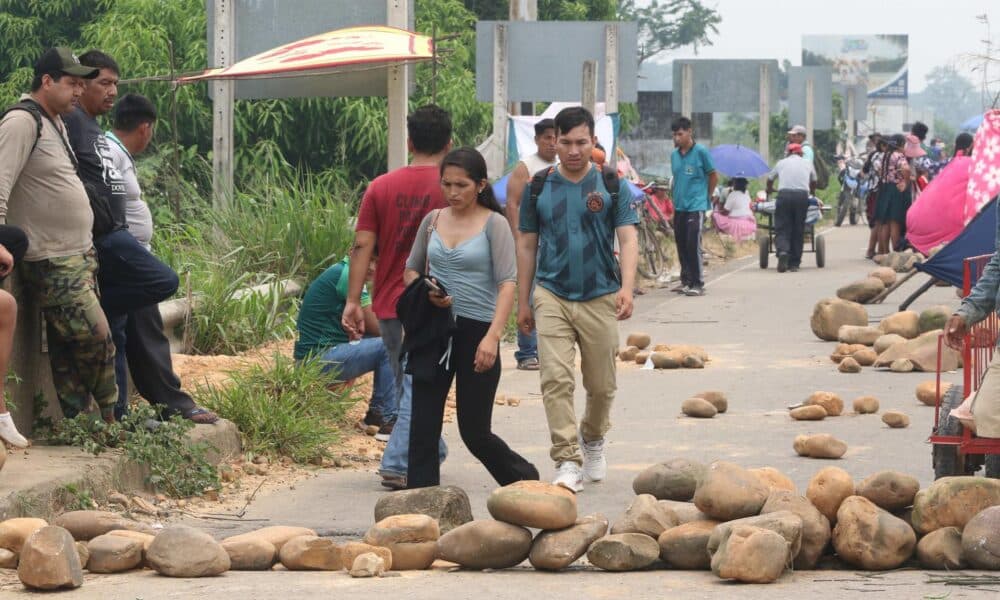 Personas caminan con sus equipajes durante un bloqueo instalado por seguidores del expresidente Evo Morales (2006-2019) este lunes en Puente Ichilo en el límite entre Santa Cruz y Cochabamba (Bolivia).EFE/Juan Carlos Torrejón