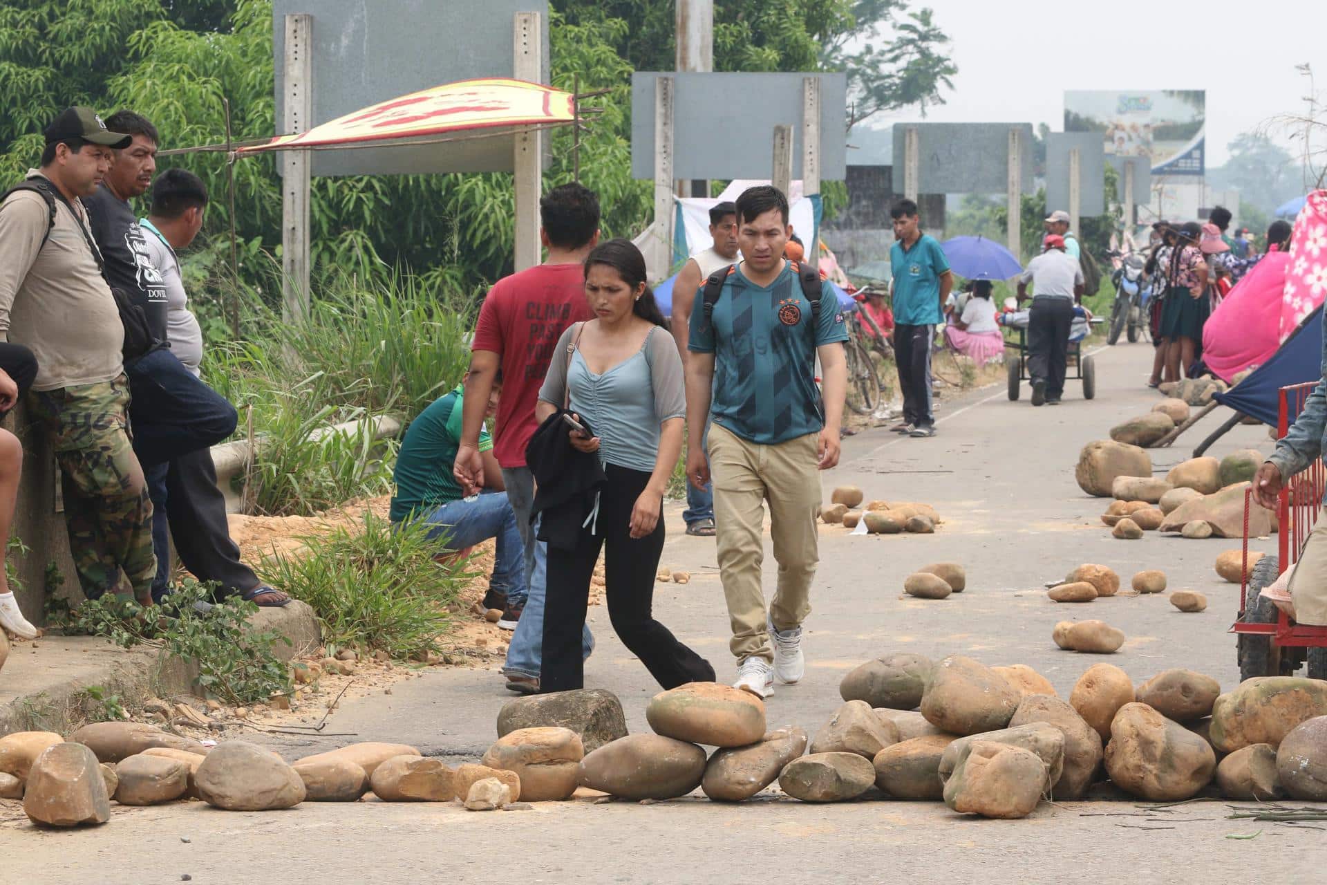 Personas caminan con sus equipajes durante un bloqueo instalado por seguidores del expresidente Evo Morales (2006-2019) este lunes en Puente Ichilo en el límite entre Santa Cruz y Cochabamba (Bolivia).EFE/Juan Carlos Torrejón