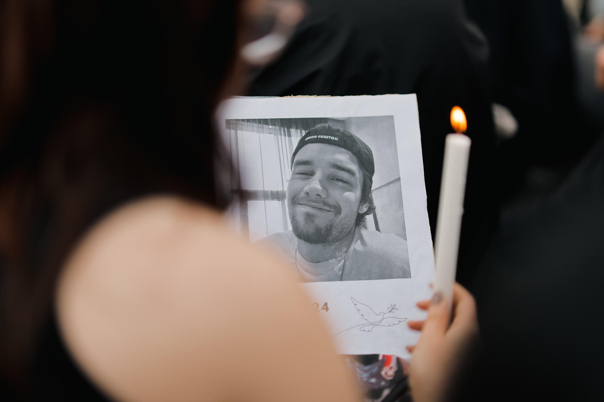 Fotografía del 17 de octubre de 2024 de una fanática que sostiene una foto del cantante Liam Payne, durante un homenaje al artista en el Obelisco en Buenos Aires (Argentina).EFE/ Juan Ignacio Roncoroni