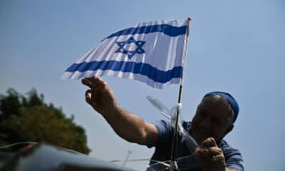 Un hombre sostiene una bandera de Israel durante una caravana en favor de la paz y el fin de la guerra, en vísperas del día en que se cumple un año del ataque de Hamas a Israel, este 6 de octubre de 2024, en Brasilia (Brasil). EFE/Andre Borges