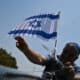 Un hombre sostiene una bandera de Israel durante una caravana en favor de la paz y el fin de la guerra, en vísperas del día en que se cumple un año del ataque de Hamas a Israel, este 6 de octubre de 2024, en Brasilia (Brasil). EFE/Andre Borges