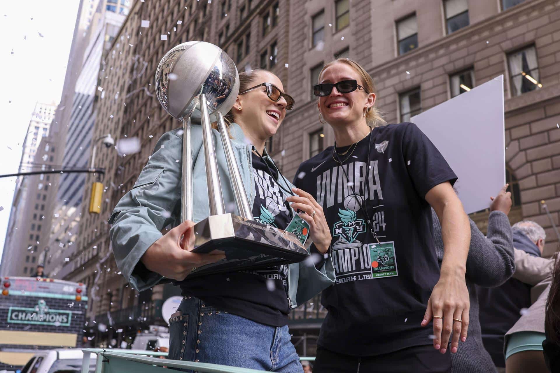 Las jugadoras de las New York Liberty Ivana Dojkic (i) y Leonie Fiebich (d) celebran con el trofeo de campeonas de la WNBA en la ciudad de Nueva York. EFE/SARAH YENESEL