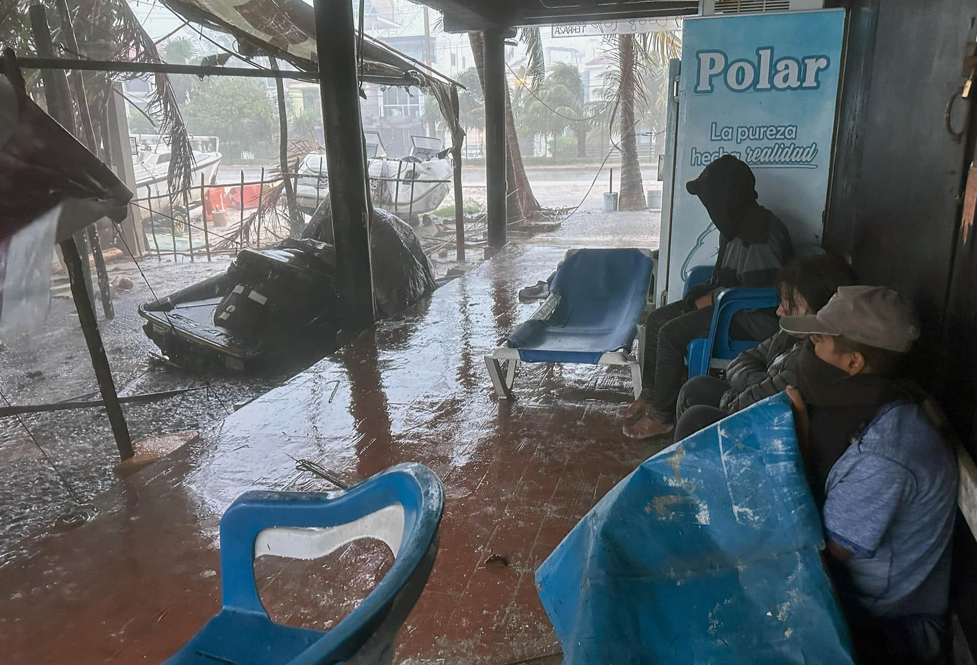 Imagen de archivo de unas personas que se protegen de las lluvias provocadas por un huracán en Cancún (México). EFE/ Alonso Cupul