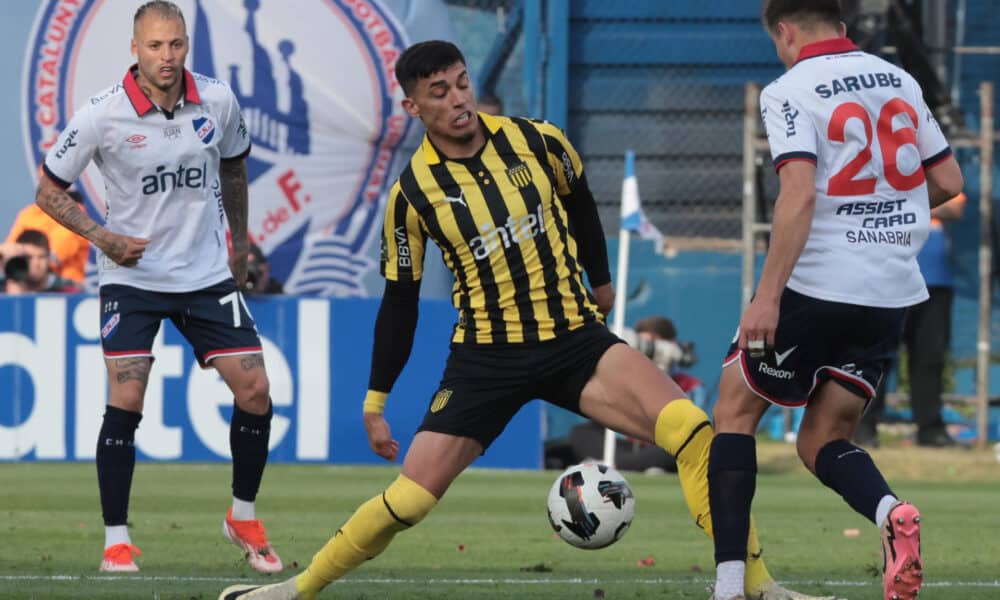 Lucas Sanabria (d) de Nacional disputa un balón con Leonardo Sequeira de Peñarol. EFE/ Gaston Britos