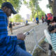 Fotografía que muestra un inmigrante mientras le corta el cabello a otro afuera del refugio de Randall Island en Nueva York (EE.UU.). EFE/Angel Colmenares