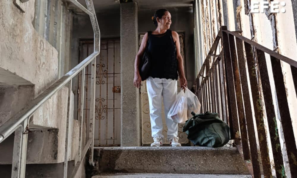 Fotografía del 6 de octubre de 2024 de una mujer caminando en un edificio sin corriente eléctrica en La Habana (Cuba). EFE/ Ernesto Mastrascusa