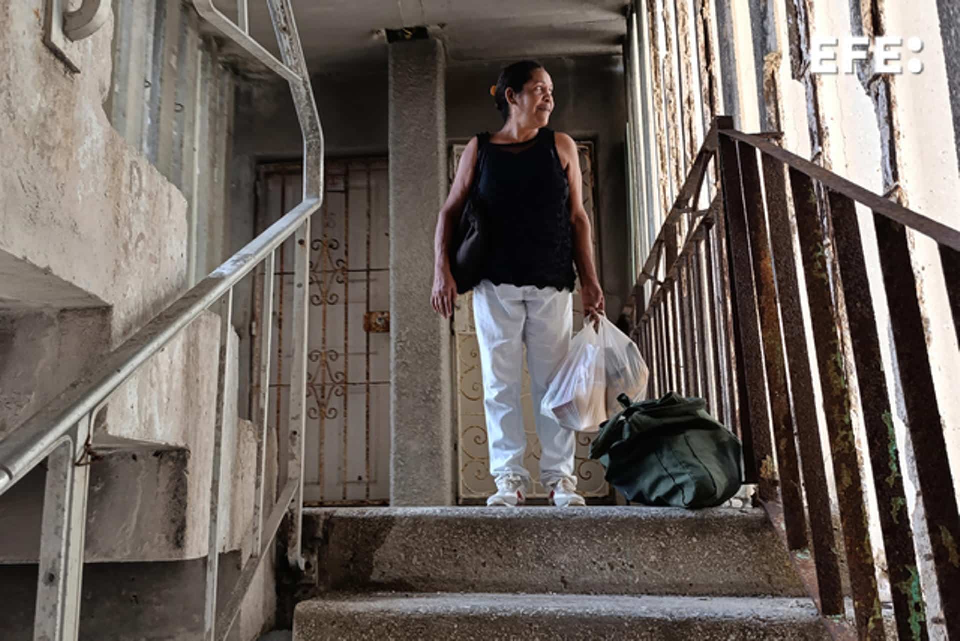 Fotografía del 6 de octubre de 2024 de una mujer caminando en un edificio sin corriente eléctrica en La Habana (Cuba). EFE/ Ernesto Mastrascusa