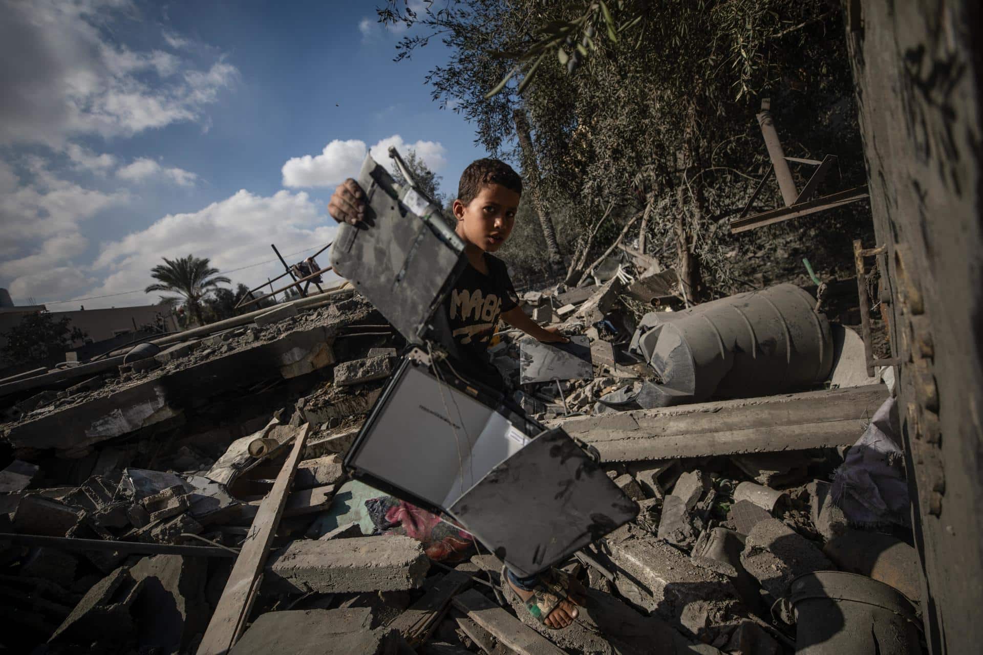 Fotografía de un niño palestino entre los escombros de un edificio destruido en la Franja de Gaza. EFE/Mohammed Saber