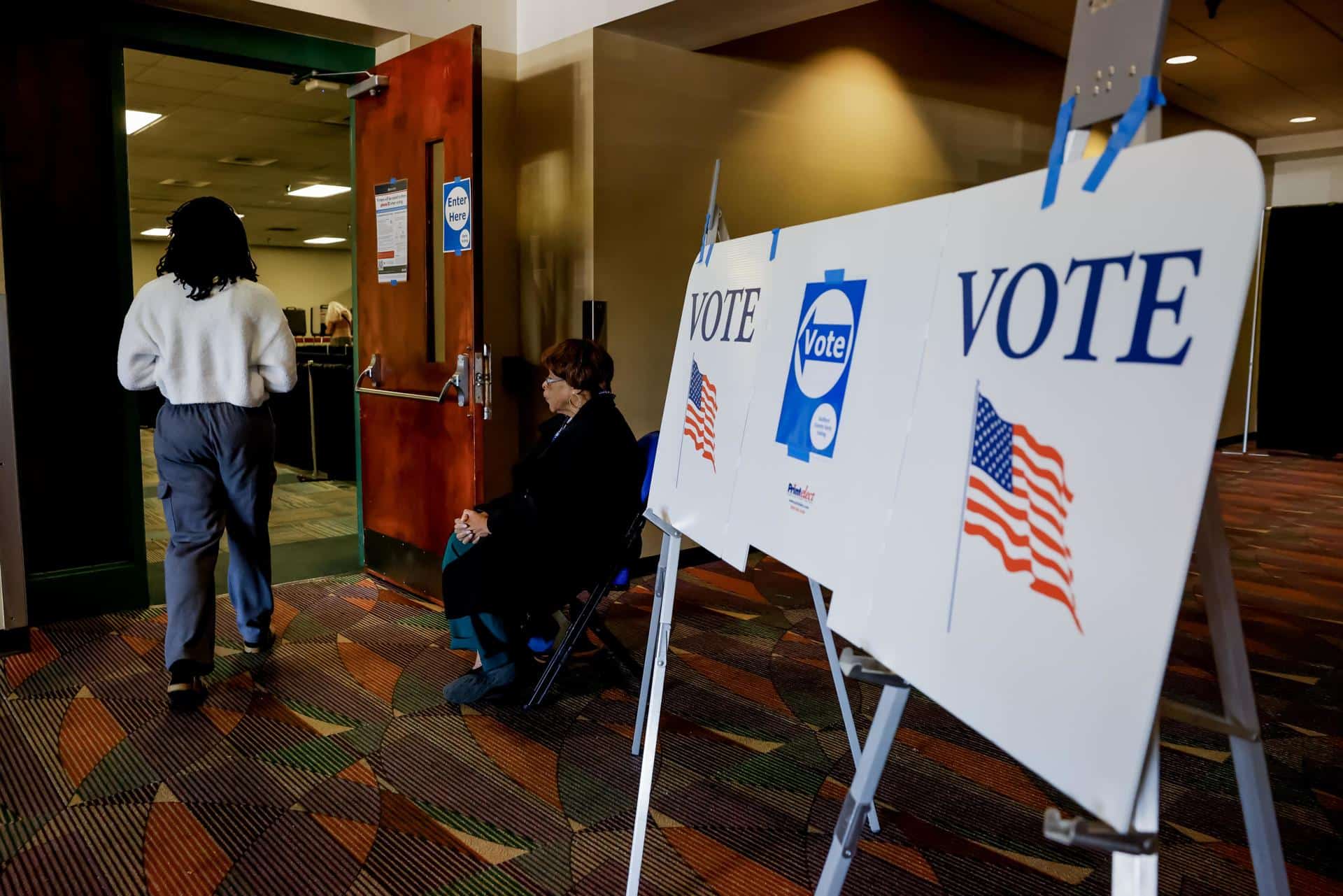 Los votantes participan en la votación anticipada en el Greensboro Coliseum mientras sus partidarios se reúnen afuera para escuchar al expresidente estadounidense y candidato presidencial republicano Donald Trump hablar en un mitin de campaña en el Greensboro Coliseum en Greensboro, Carolina del Norte, EE. UU., el 22 de octubre de 2024. EFE/EPA/Erik S. Lesser