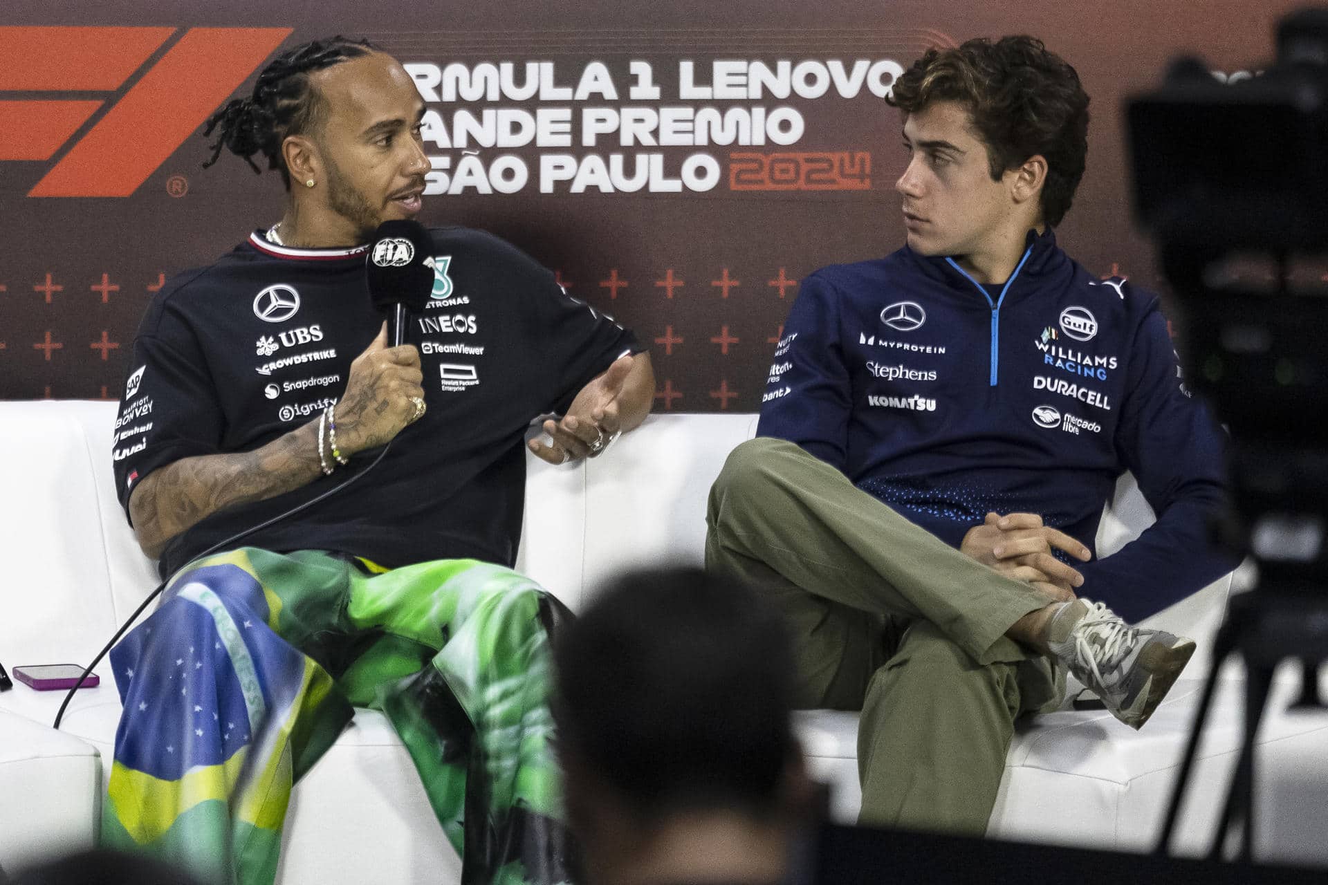 El piloto británico de la escudería Mercedes, Lewis Hamilton (i), conversa con el piloto de Williams, el argentino Franco Colapinto, a quien elogió por el "fantástico" trabajo realizado en la F1. EFE/ Isaac Fontana