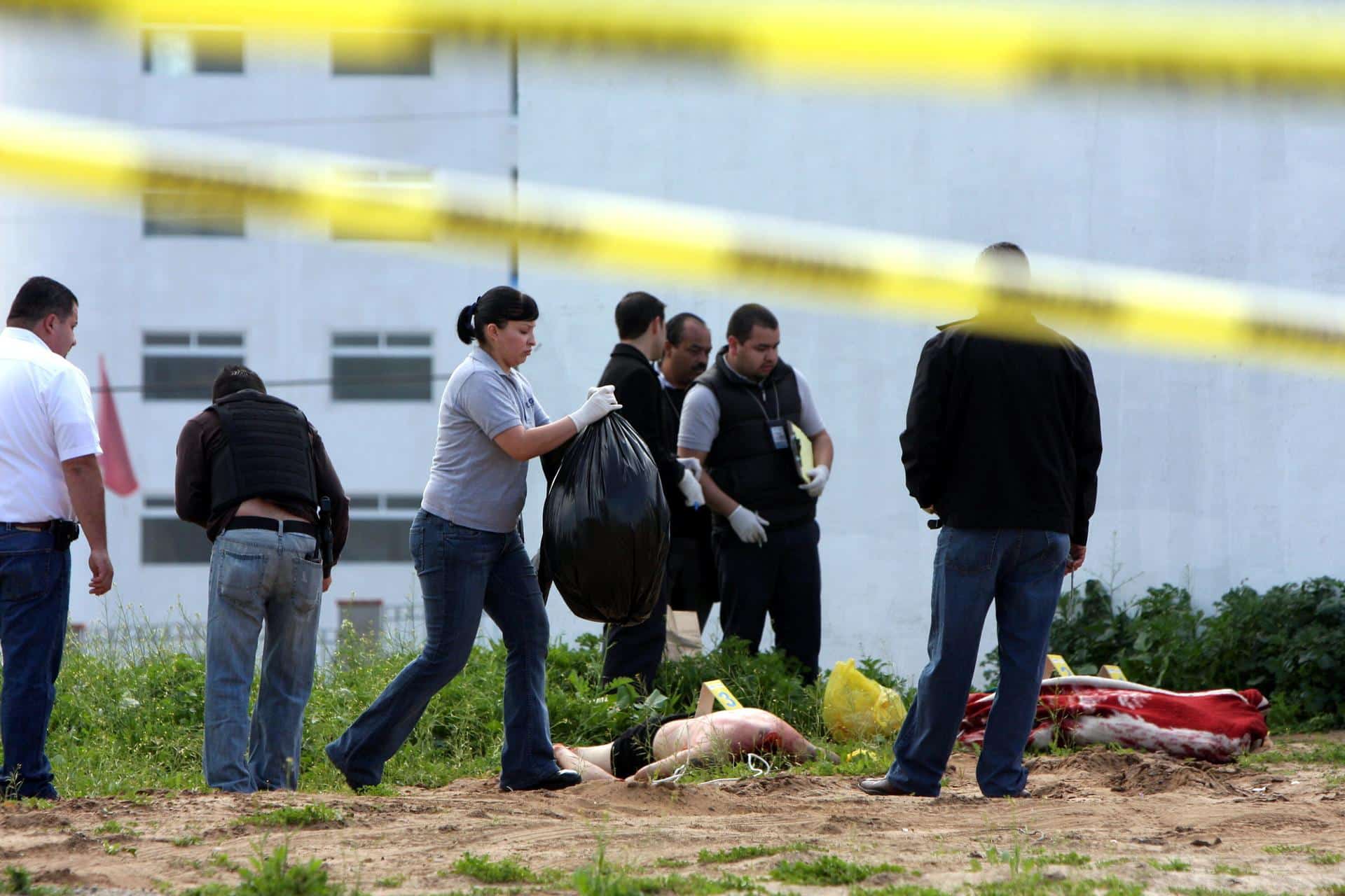 Imagen de archivo de expertos forenses que realizan investigaciones en el lugar donde fueron encontrados hombres decapitados. EFE/Str