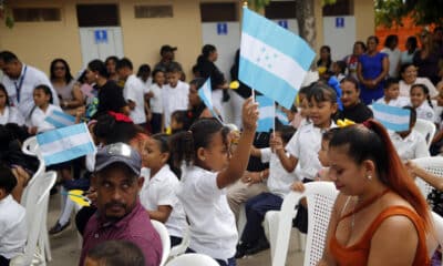 Una estudiante del Centro de Educación Básica Armando Montes levanta una bandera de Honduras en Juticalpa (Honduras). EFE/ Gustavo Amador