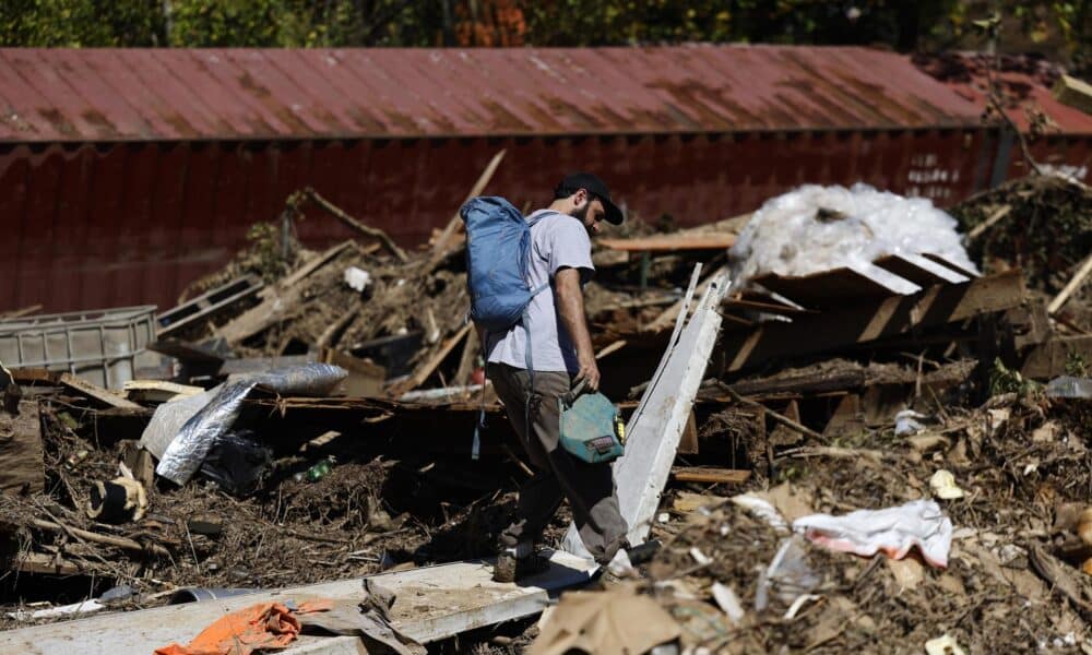 Una persona camina entre los escombros tras las inundaciones causadas por Helene en Asheville (EE.UU.). EFE/EPA/ERIK S. LESSER