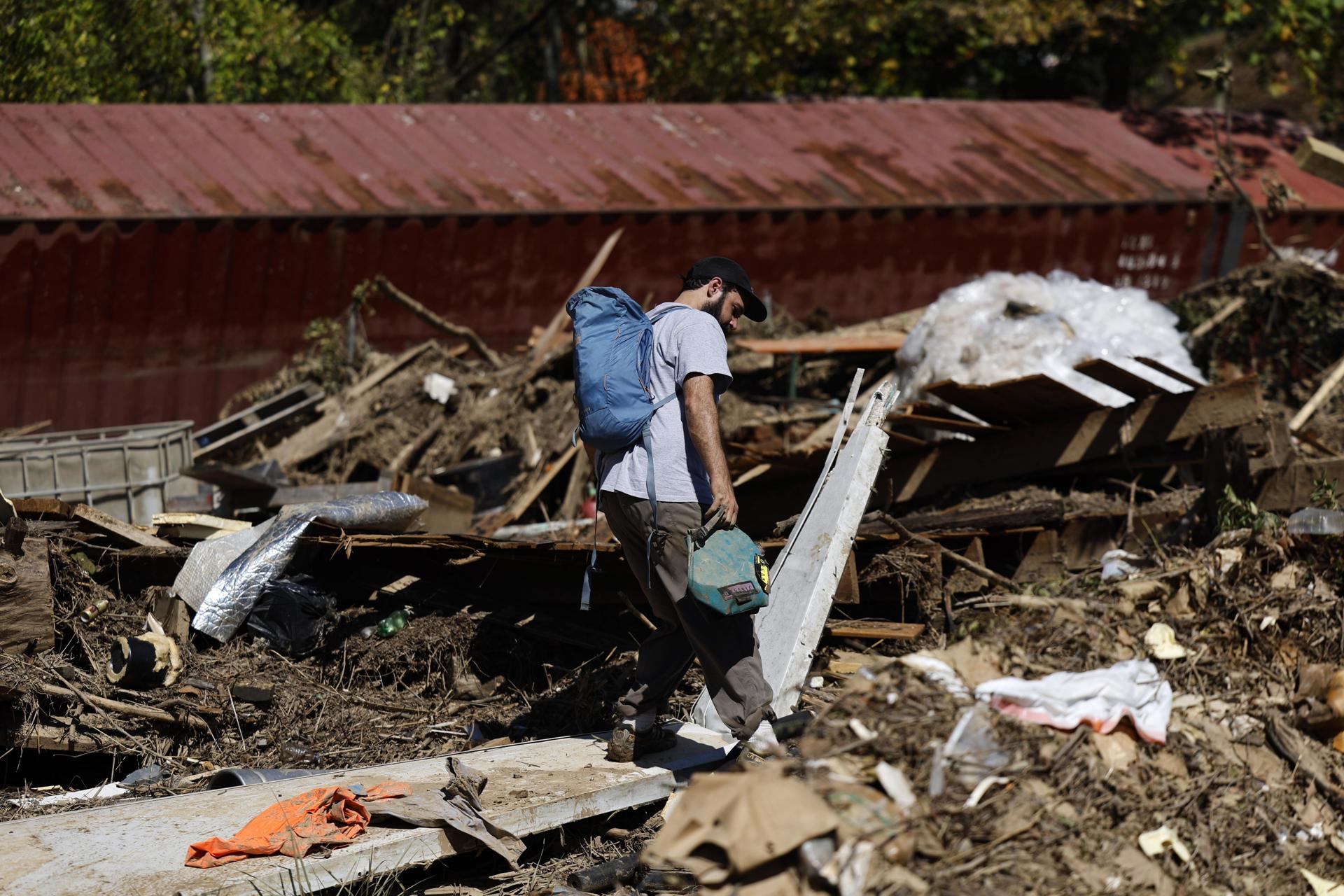 Una persona camina entre los escombros tras las inundaciones causadas por Helene en Asheville (EE.UU.). EFE/EPA/ERIK S. LESSER