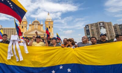 Fotografía del 28 de agosto de 2024 en donde se ven manifestantes que sostienen banderas durante una protesta convocada por María Corina Machado, frente a la Basílica de nuestra señora de Chiquinquirá en Maracaibo (Venezuela). EFE/ Henry Chirinos