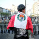 Un manifestante sostiene una bandera de Perú frente a miembros de la policía durante una protesta cerca al Congreso de la República este jueves, en Lima (Perú). EFE/ STR