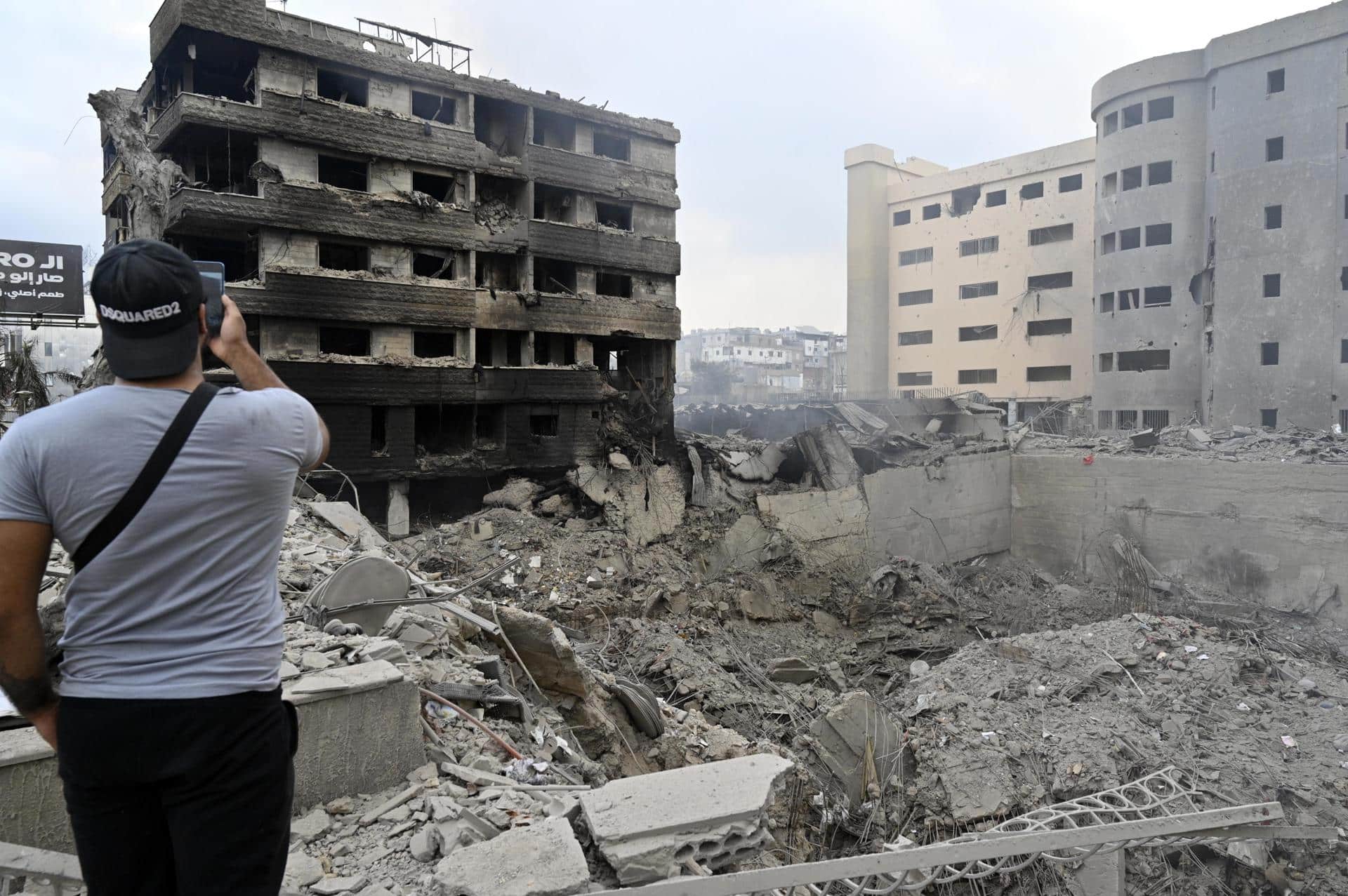 Un hombre toma fotos el lunes de los daños causados tras un ataque aéreo israelí en la carretera del aeropuerto en el suburbio sur de Beirut, Líbano, 07 de octubre de 2024. Según el ministro de Sanidad libanés, más de 2.000 personas han muerto y más de 9.600 han resultado heridas en Líbano desde el comienzo del conflicto entre Israel y Hezbolá. EFE/WAEL HAMZEH