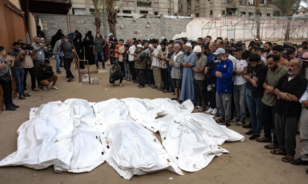 Palestinos rezan junto a los cadáveres de los miembros de una familia muertos en un ataque aéreo israelí en el sur de la Franja de Gaza, el 15 de octubre de 2024. EFE/EPA/HAITHAM IMAD