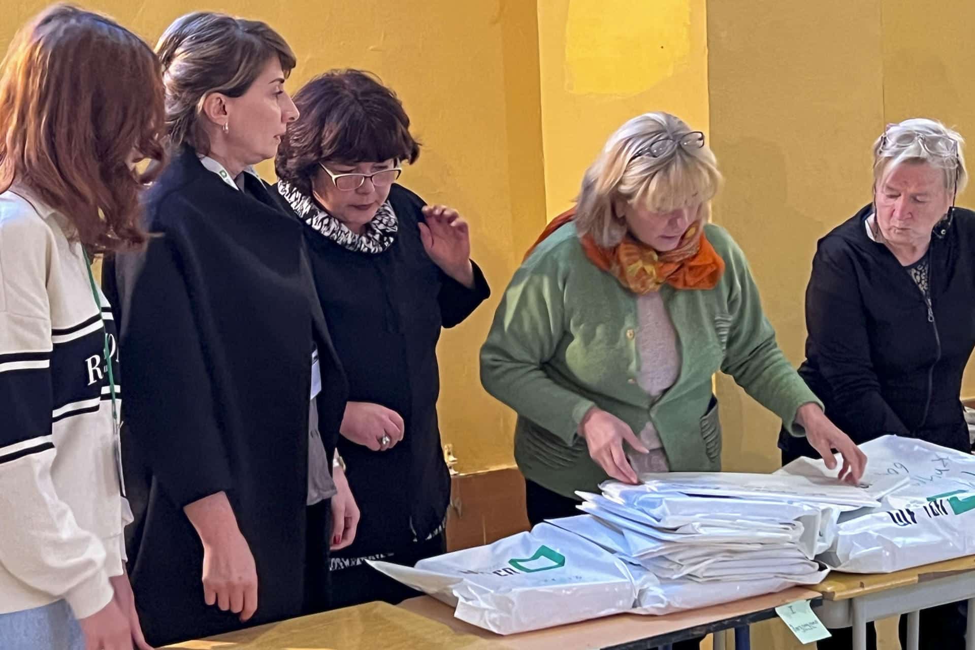 Varias personas durante el recuento de votos de las elecciones parlamentarias del pasado sábado en Georgia, este martes. La Comisión Electoral Central (CEC) de Georgia anunció hoy que efectuará un recuento de los sufragios emitidos en las elecciones parlamentarias del pasado sábado en cinco colegios de cada una de las 73 circunscripciones electorales del país. EFE/ Misha Vignanski