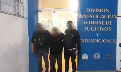 Fotografía cedida por la Policía Federal de Argentina, editada por esa fuente, que muestra a dos agentes custodiando al dominicano Peter Francis Kennedy (c), detenido y buscado por la Justicia de Colombia, en Buenos Aires (Argentina). EFE/ Policía Federal Argentina