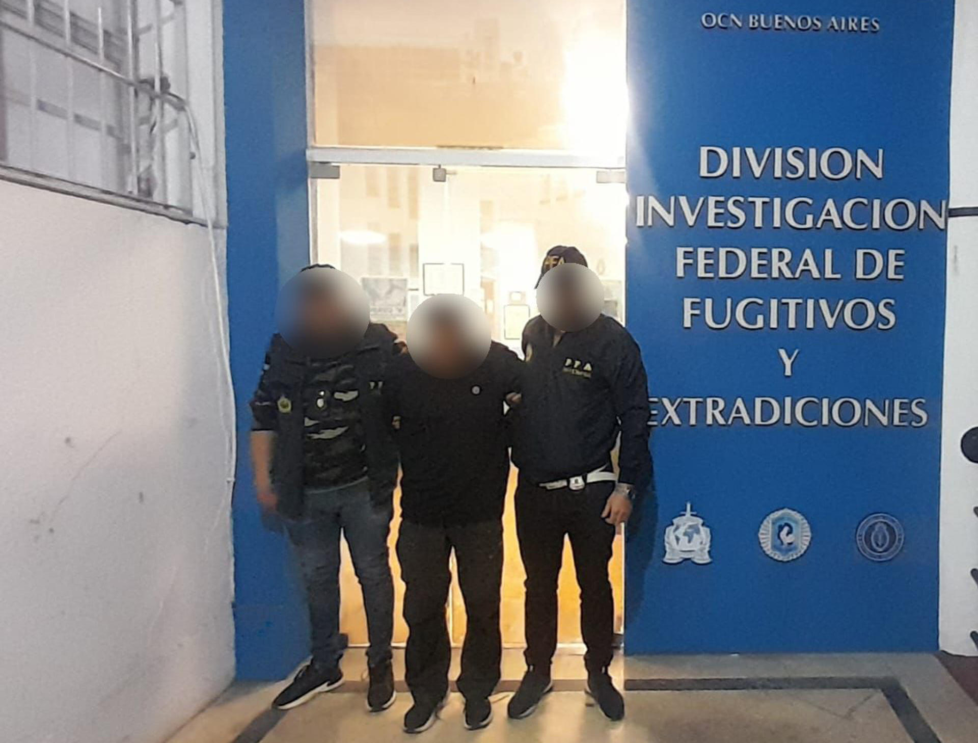 Fotografía cedida por la Policía Federal de Argentina, editada por esa fuente, que muestra a dos agentes custodiando al dominicano Peter Francis Kennedy (c), detenido y buscado por la Justicia de Colombia, en Buenos Aires (Argentina). EFE/ Policía Federal Argentina