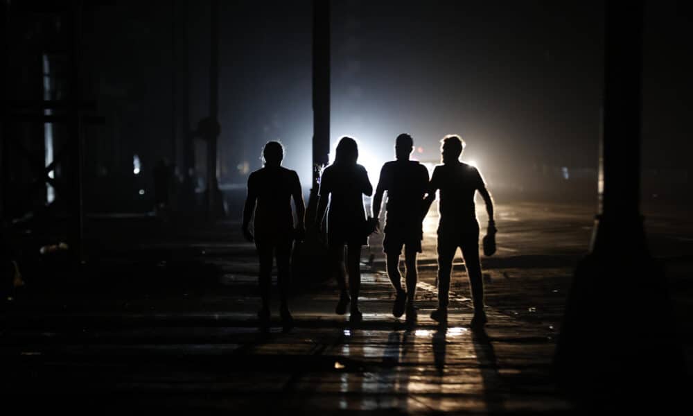 Personas caminan por una calle durante un apagón el domingo, en La Habana (Cuba). EFE/ Ernesto Mastrascusa