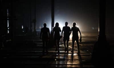 Personas caminan por una calle durante un apagón el domingo, en La Habana (Cuba). EFE/ Ernesto Mastrascusa