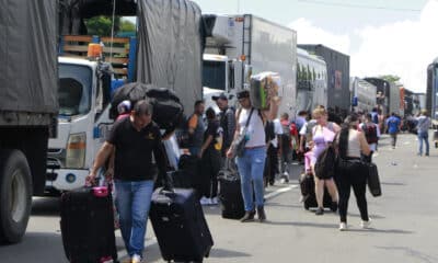 Personas caminan con sus equipajes durante una protesta este lunes, en el peaje de Los Acacios, en el Municipio de Los Patios, en Cúcuta (Colombia). Campesinos del nororiente colombiano comenzaron una protesta para pedir extender la frontera agrícola en los páramos y cultivar en este ecosistema protegido. EFE/ Mario Caicedo