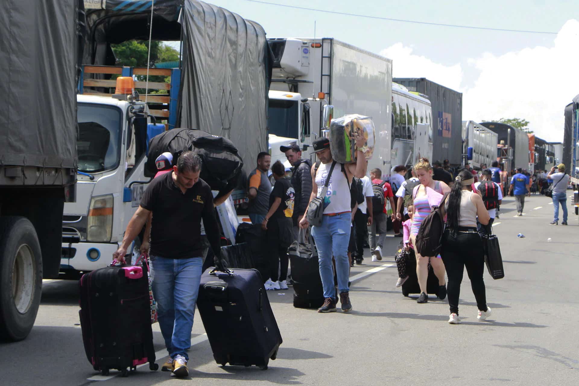 Personas caminan con sus equipajes durante una protesta este lunes, en el peaje de Los Acacios, en el Municipio de Los Patios, en Cúcuta (Colombia). Campesinos del nororiente colombiano comenzaron una protesta para pedir extender la frontera agrícola en los páramos y cultivar en este ecosistema protegido. EFE/ Mario Caicedo