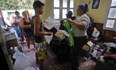 Una mujer entrega donaciones a afectados por el paso de la tormenta tropical Óscar, en el poblado de Imias, en la región de San Antonio del Sur, este miércoles en la provincia de Guantánamo, a más de 900 km de La Habana (Cuba). EFE/ Ernesto Mastrascusa / POOL