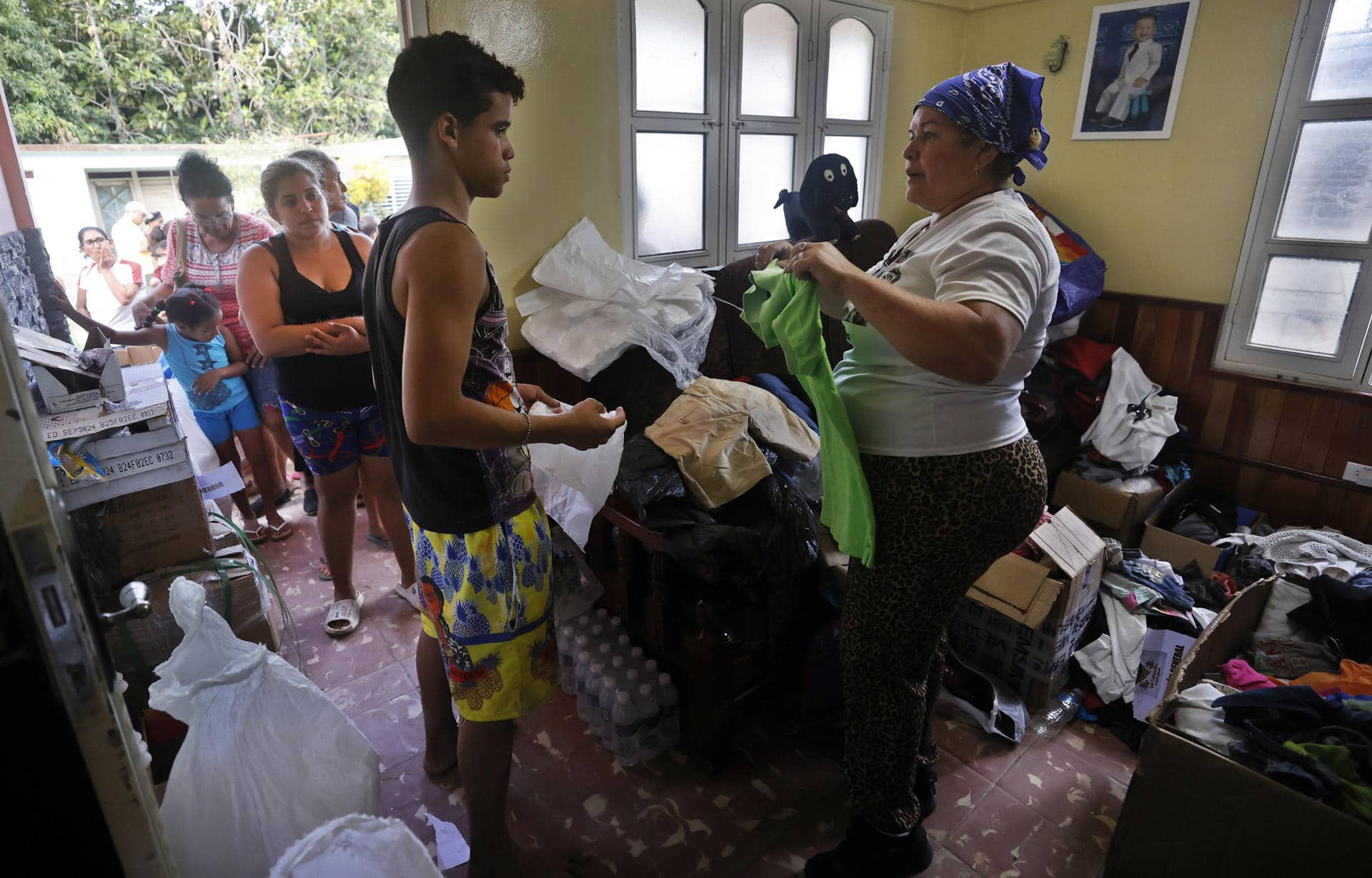 Una mujer entrega donaciones a afectados por el paso de la tormenta tropical Óscar, en el poblado de Imias, en la región de San Antonio del Sur, este miércoles en la provincia de Guantánamo, a más de 900 km de La Habana (Cuba). EFE/ Ernesto Mastrascusa / POOL