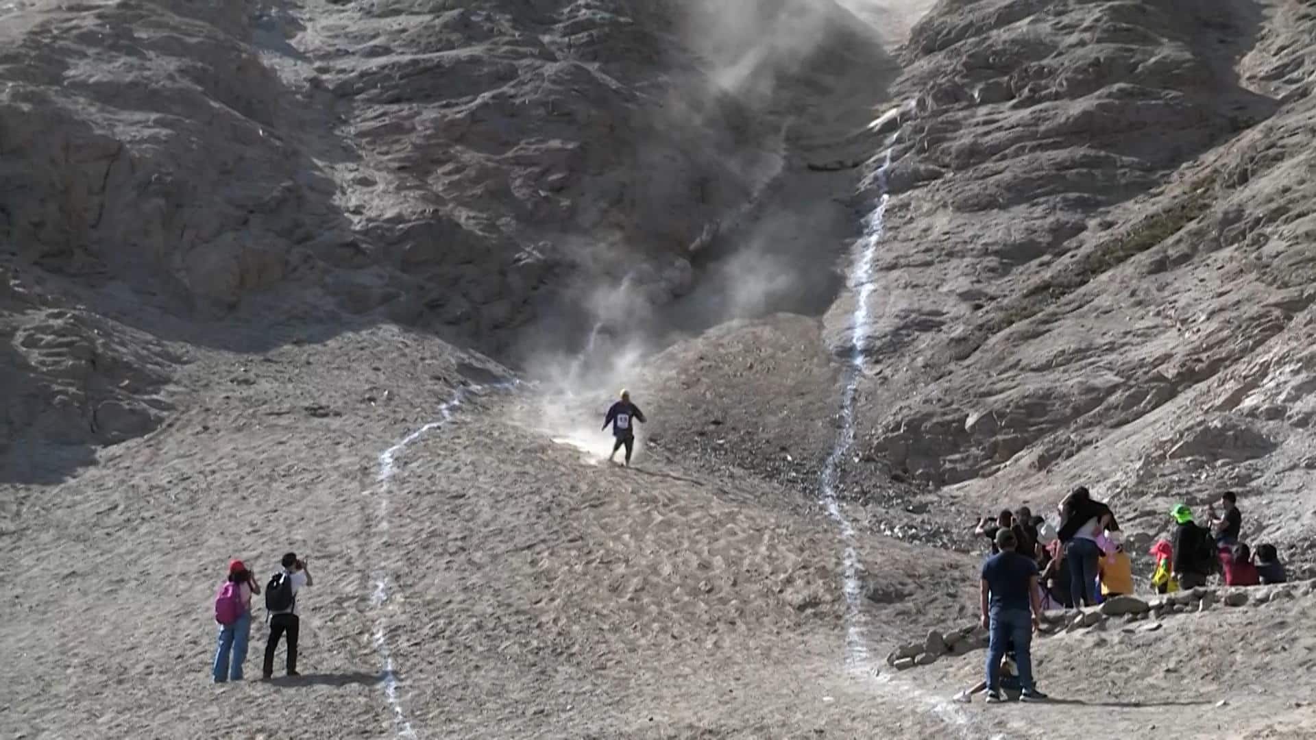 Captura de pantalla de turistas peruanos deslizándose en el 'Tobogán macho', un cerro de más de 280 metros de altura situado al sur de Lima (Perú). "Valor, coraje y atrevimiento" son las características que destacan a los participantes de este reto, que consiste en descender lo más rápido posible desde un cerro de 289 metros de altura, sin ningún equipo de protección o asistencia médica. EFE