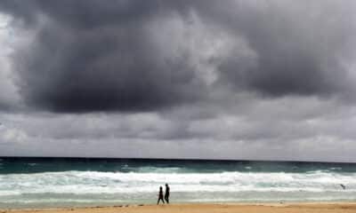 Imagen de archivo de turistas que caminan en la zona de playas que lucen con banderas rojas por los fuertes vientos que se registranen la ciudad mexicana de Cancún, en el estado de Quintana Roo (México). EFE/Alosnso Cupul