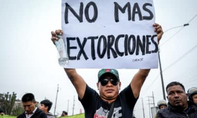 Un hombre sostiene un cartel durante una jornada de paro de transportadores, este jueves, en la ciudad de Lima (Perú). EFE/STR